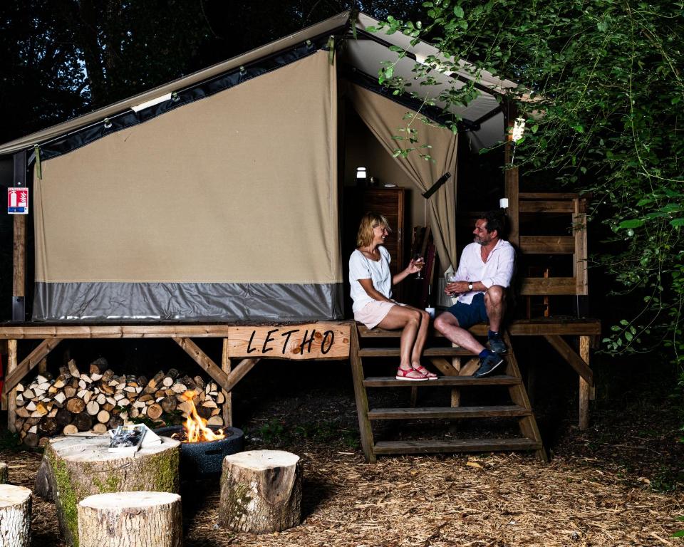 2 femmes assises sur une échelle dans une tente dans l'établissement Lodge Dormir au chant des loups, à Sury-aux-Bois