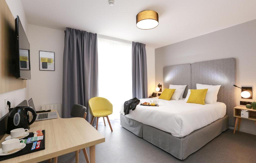 um quarto de hotel com uma cama, uma mesa e uma secretária em Odalys City Angers Centre Gare em Angers