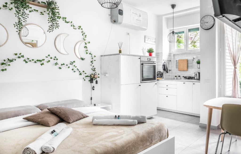 una cucina bianca con un grande letto in una stanza di [Eden House SanSiro-Duomo] Netflix & Design a Milano