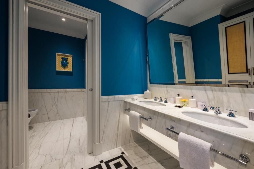 a blue bathroom with a sink and a mirror at Grand Hotel San Pietro Taormina in Taormina