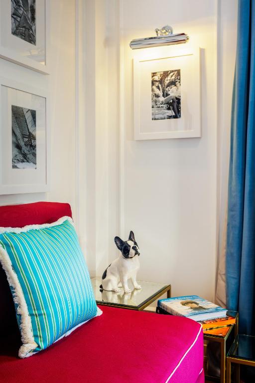 a cat sitting on a table next to a red couch at Grand Hotel San Pietro Taormina in Taormina