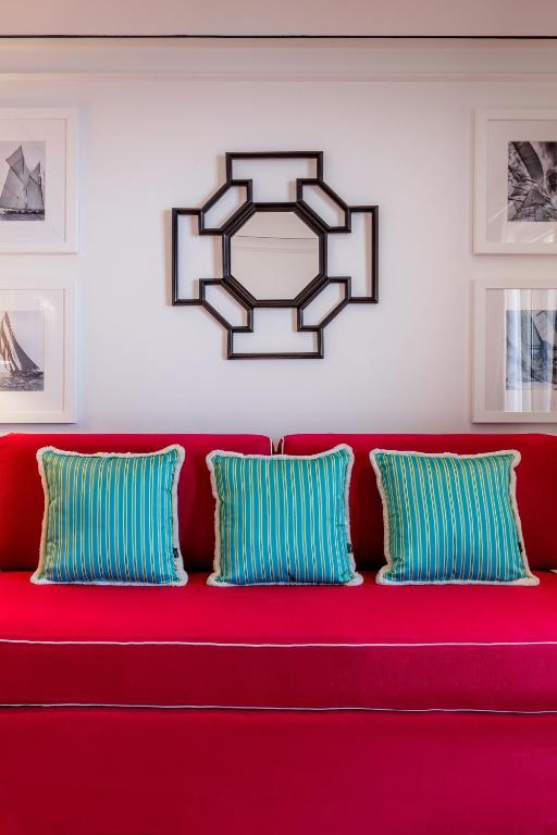 a red couch with blue and white pillows on it at Grand Hotel San Pietro Taormina in Taormina