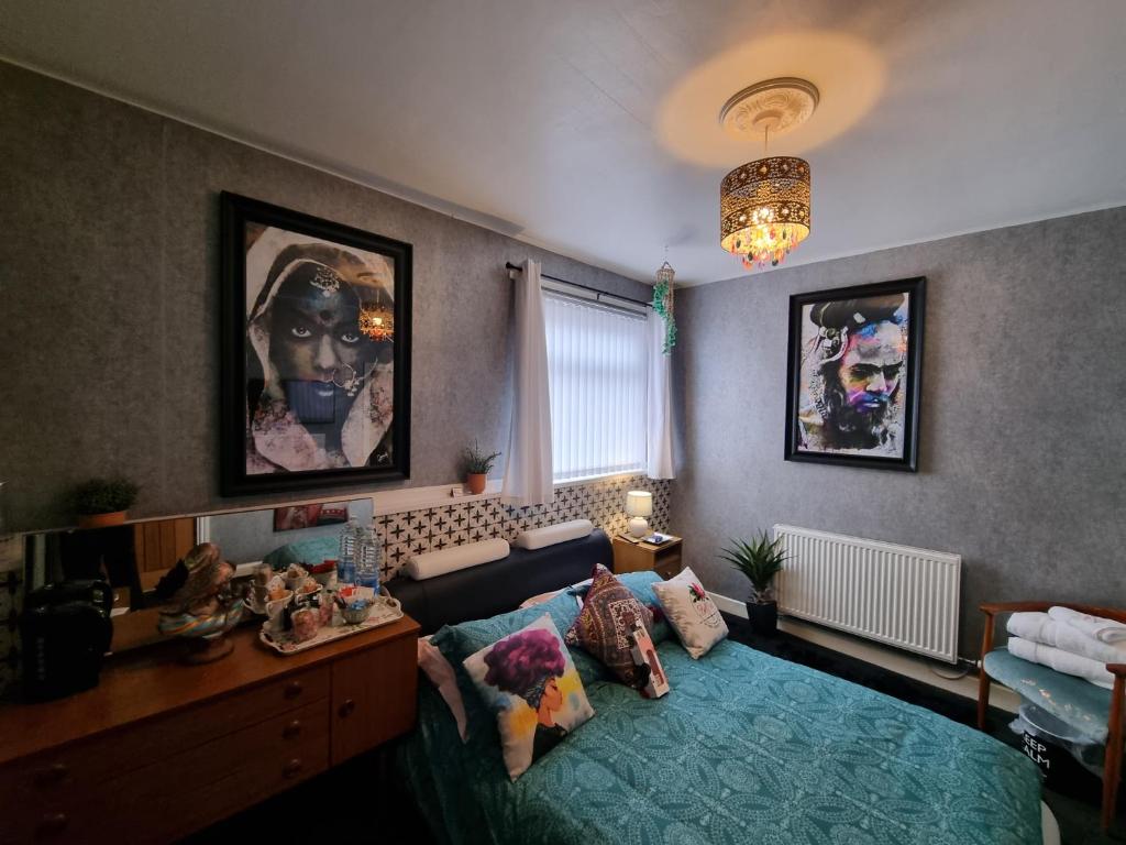 Schlafzimmer mit einem Bett, einem Schreibtisch und einem Kronleuchter in der Unterkunft TIFFY'S PLACE Adult Guest House in Blackpool