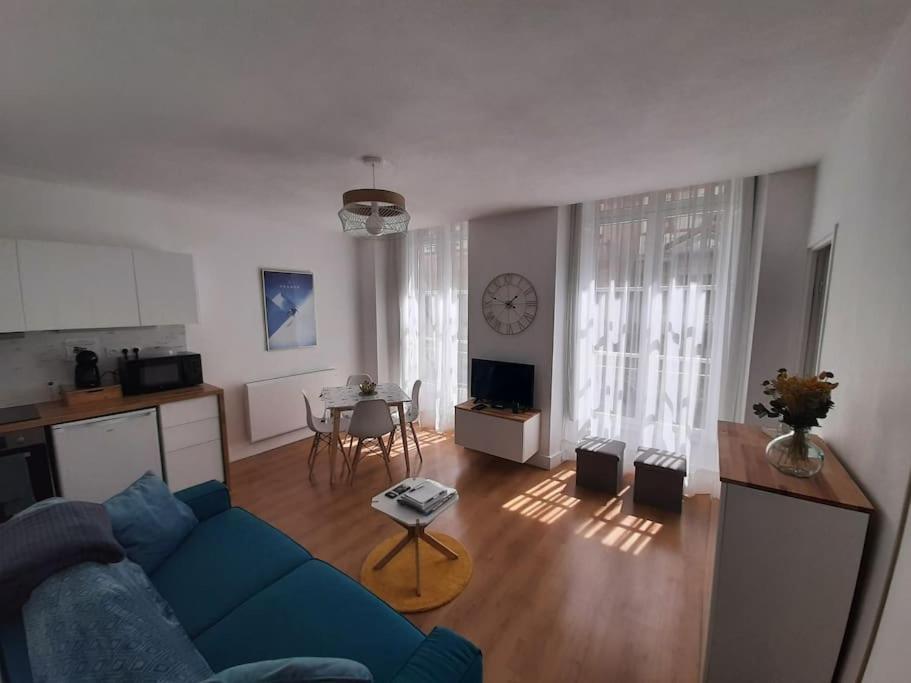 un salon avec un canapé bleu et une table dans l'établissement Appartement 3* joliment rénové à 150m des thermes, à Luchon