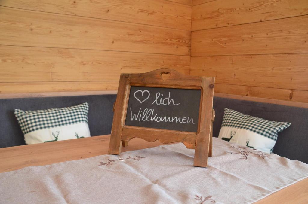 un cartel en la parte superior de una cama en una habitación en Lärche 2 - Chiemgaukarte inklusive-, en Inzell