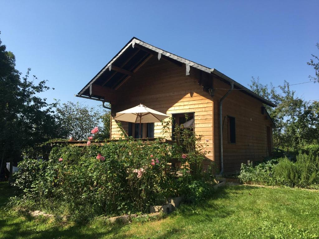 a small house with an umbrella in a yard at Chalet à la campagne in Clais