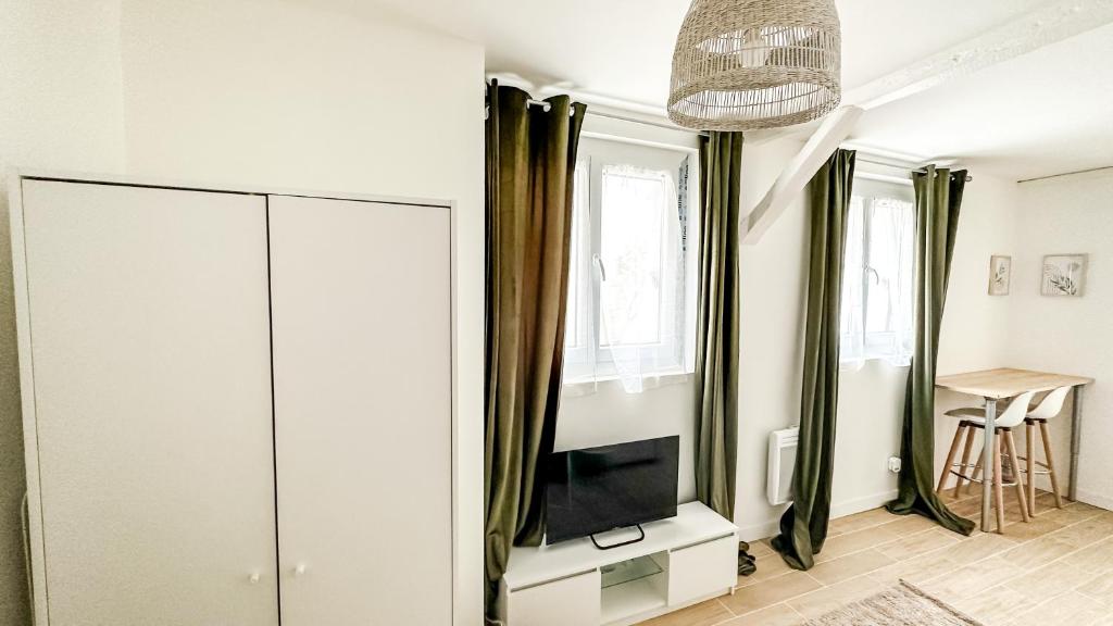 a living room with a tv and a white cabinet at Le Kaki Bohème - Studio proche Université de Paris 13 in Villetaneuse