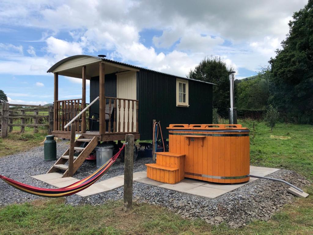 a small playground with a house and a slide at Shepherds Hut at The Retreat in Oswestry