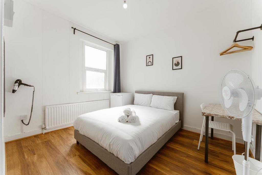 倫敦的住宿－Leyton Comfy Double rooms - 50，一间卧室配有一张床、一张书桌和一个窗户。