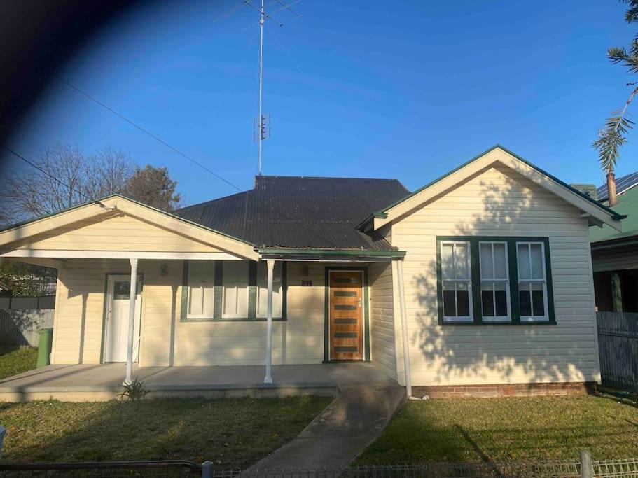a white house with a antenna on top of it at Golden Street Cottage in West Wyalong