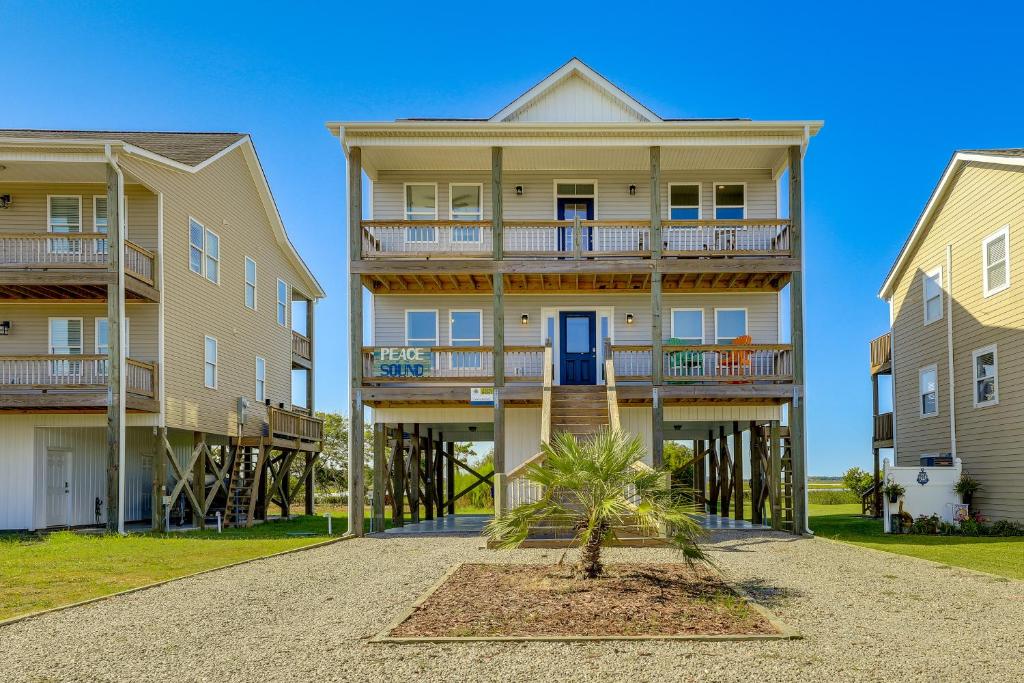 Edificio Aominium con una palmera delante. en North Topsail Getaway with Panoramic Sound Views!, en North Topsail Beach