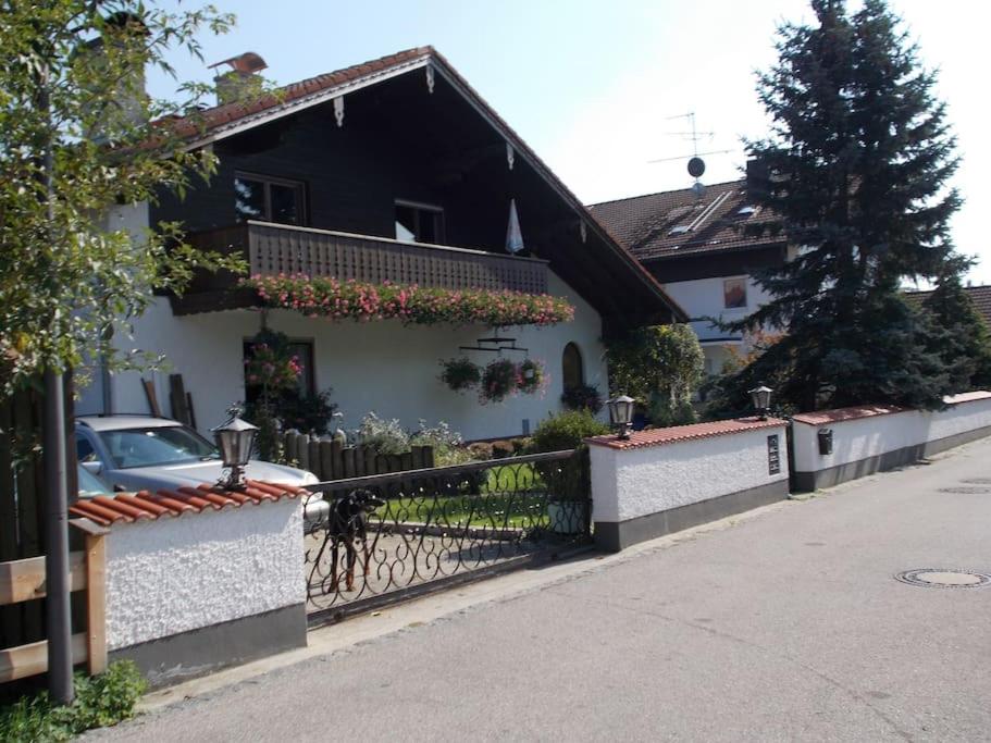 ein Haus mit einem Zaun und einem Auto auf der Straße in der Unterkunft 140qm in 83052 between Munich+Rosenheim in Bruckmühl
