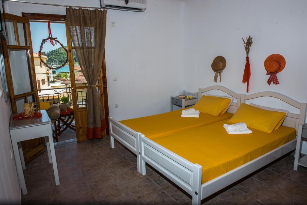 1 dormitorio con 1 cama con sábanas amarillas y ventana en Summer Bed Nydri, en Nydri