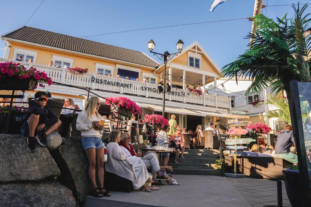 eine Gruppe von Personen, die außerhalb eines Gebäudes sitzen in der Unterkunft Hotel Lyngørporten in Gjeving