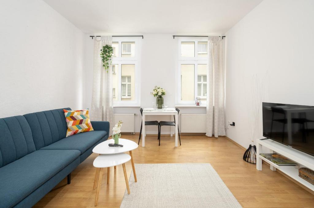 波茲南的住宿－Bright & Comfortable Apartment Garbary 35 Poznań Old Town by Renters，客厅配有蓝色的沙发和桌子