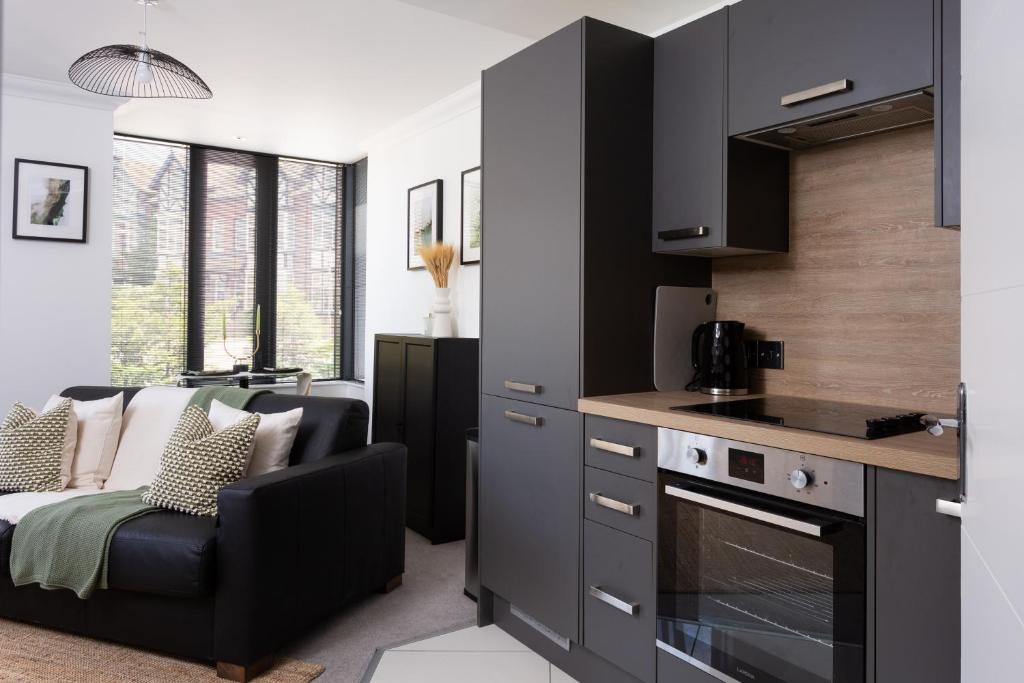 una cucina con armadi neri e un soggiorno di London Mews, modern apartment - sleeps 4 a York