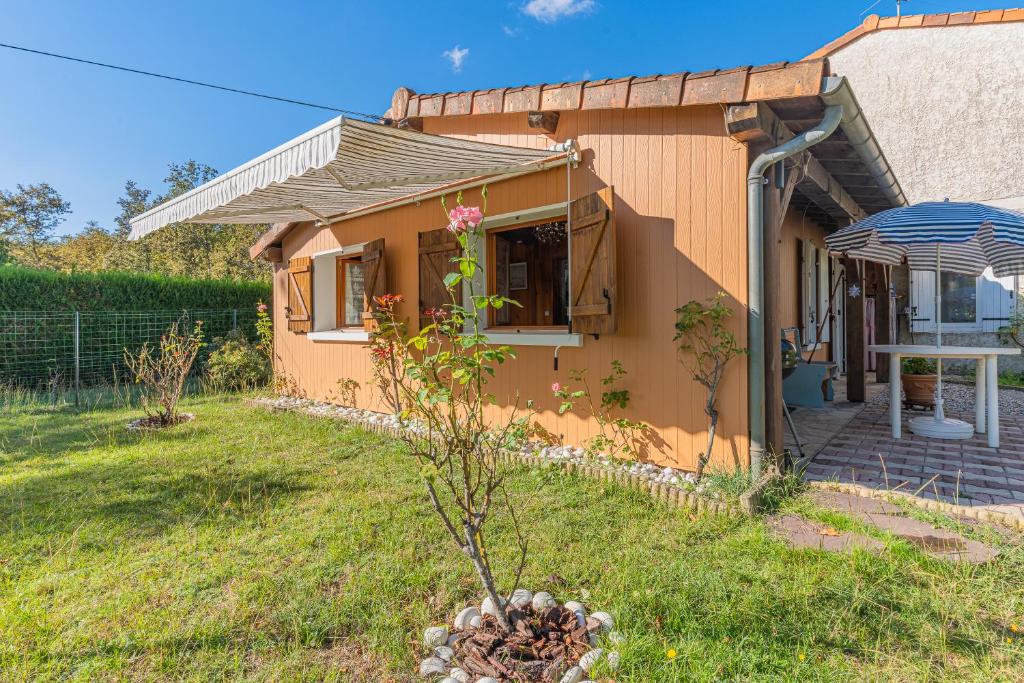 una pequeña casa con una planta en el patio en Charme De L'ancien Et Du Moderne, en Mios