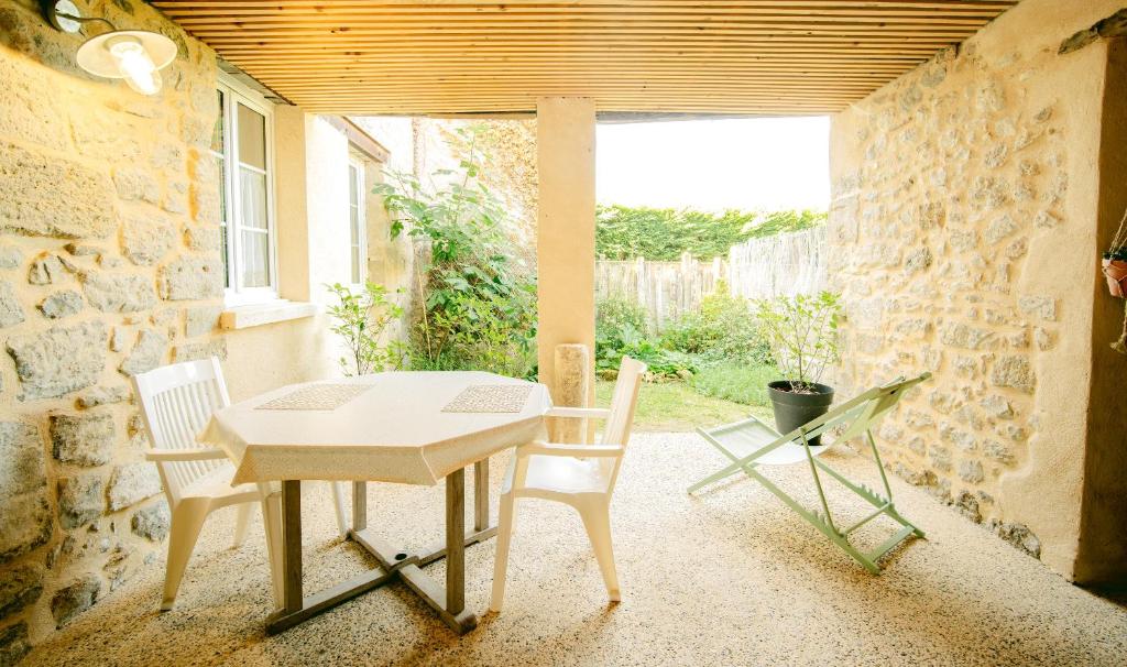 une salle à manger avec une table et deux chaises dans l'établissement La Petite Bachelière - terrasse couverte extérieure et jacuzzi, à La Bachellerie