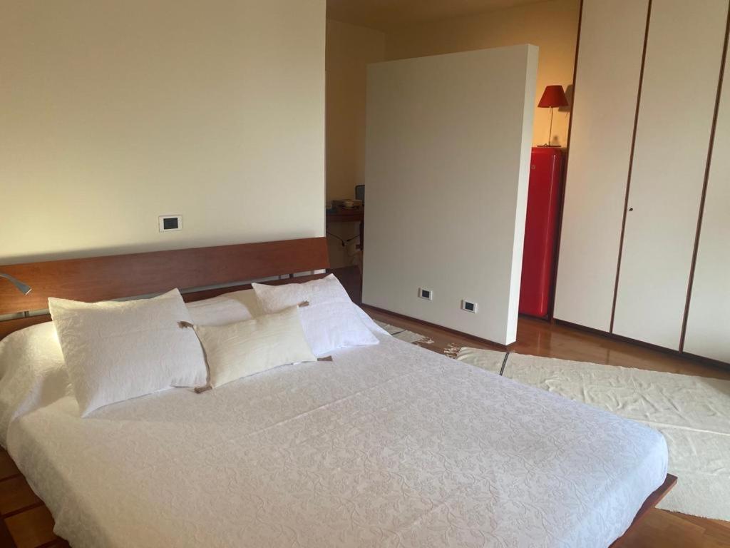 - une chambre dotée d'un grand lit avec des draps et des oreillers blancs dans l'établissement CHAMBRE DANS LA TOUR, à Bergame