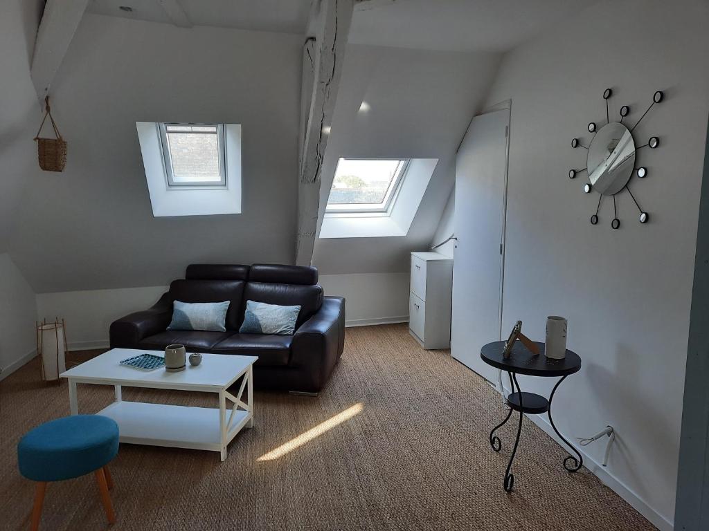 ein Wohnzimmer mit einem Ledersofa und einem Tisch in der Unterkunft La Merlette in Le Lion-dʼAngers