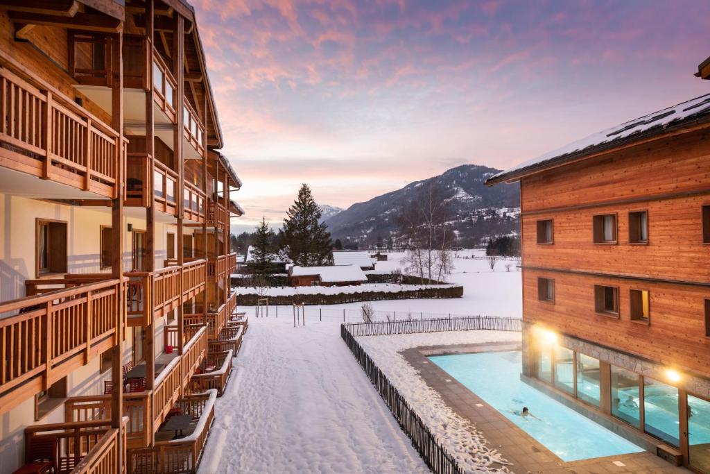a resort with a swimming pool in the snow at Résidence Club MMV Samoens in Samoëns
