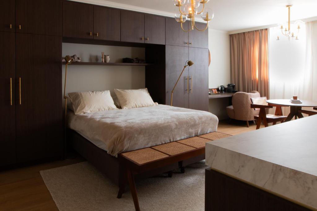 een slaapkamer met een bed en een tafel en een keuken bij B&B Midtown Amsterdam suites in Amsterdam