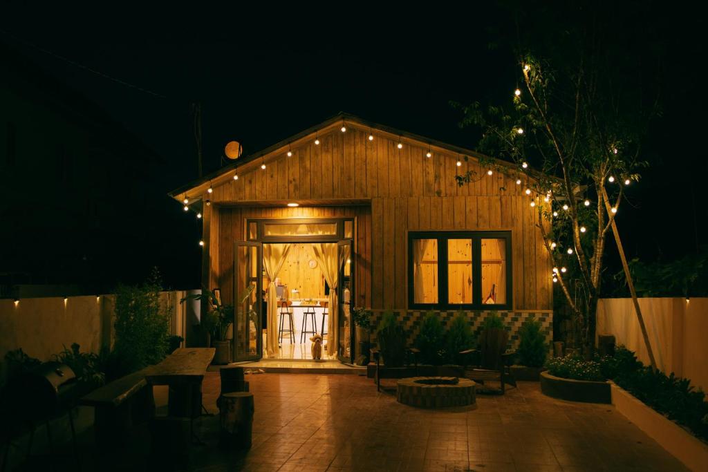 una pequeña casa de madera con luces encendidas por la noche en Là Lá La Home en Dalat