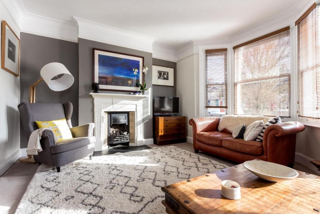 a living room with a couch and a fireplace at Elephant & Oxpecker in Fulham in London