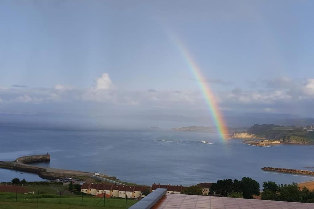a rainbow over a body of water with at La ventana al mar in Luanco