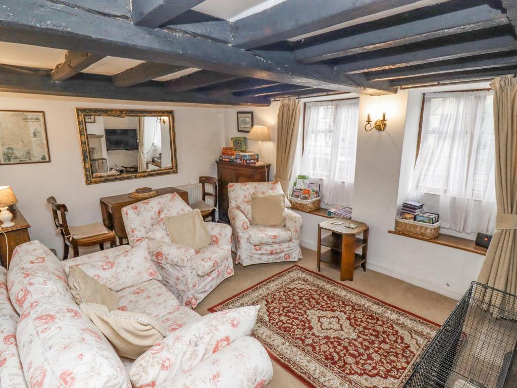 ボートン・オン・ザ・ウォーターにあるNewbury Cottageのリビングルーム(ソファ、椅子、鏡付)
