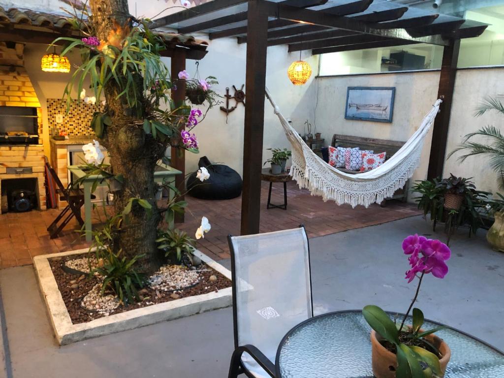 a patio with a hammock and a table and a hammock at Loft para temporada in Cabo Frio