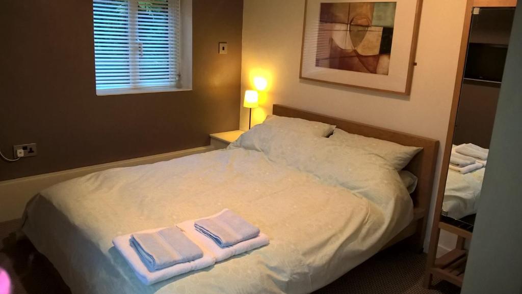 a bedroom with a bed with two towels on it at The Garden Room in Dundon