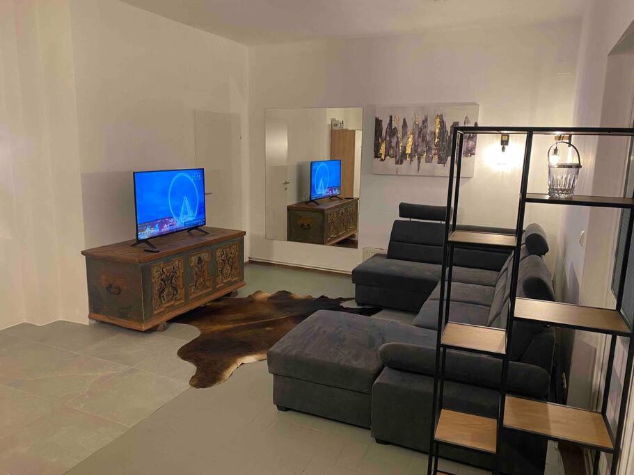 a living room with a couch and a tv at Seenahes Haus mit Hot Tub in Krumpendorf am Wörthersee