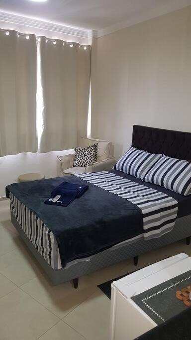 a living room with a bed and a couch at Studio 1811 Campinas SP in Campinas