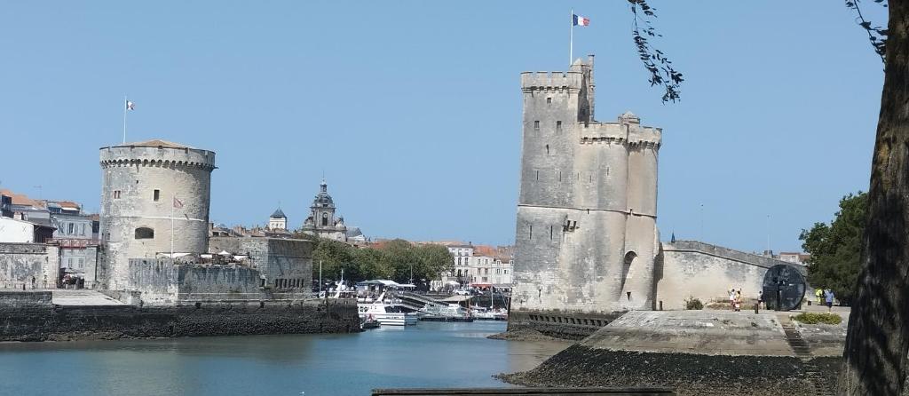 un château avec deux tours au-dessus d'une rivière dans l'établissement La Cabane Bleue, à Salles-sur-Mer