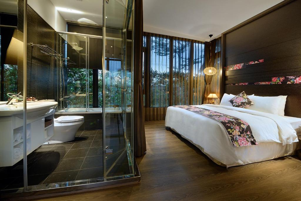 a bedroom with a bed and a shower and a sink at Pokara Resort in Jiaoxi