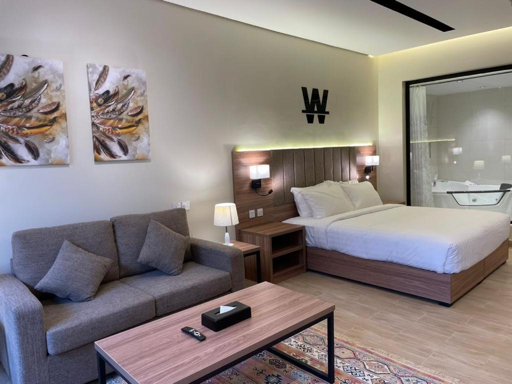 pokój hotelowy z łóżkiem i kanapą w obiekcie شاليهات دبليو سويتس الدرب w mieście Qarār