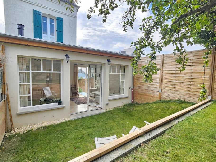 una casa con un patio con sillas delante en Maison familiale, 3 chambres, jardin, au calme, en Trouville-sur-Mer