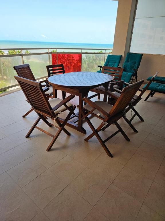 uma mesa e cadeiras num quarto com uma varanda em Edificio Mondrian 1ª Linea vistas al mar em Oropesa del Mar