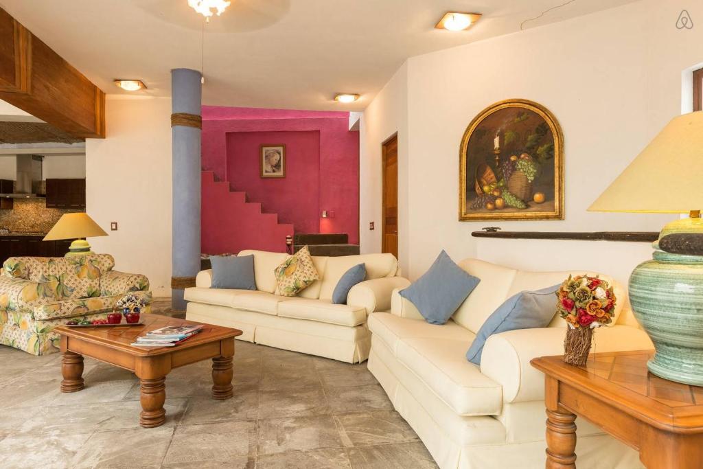 a living room with two couches and a table at Casa La Columna in Puerto Vallarta