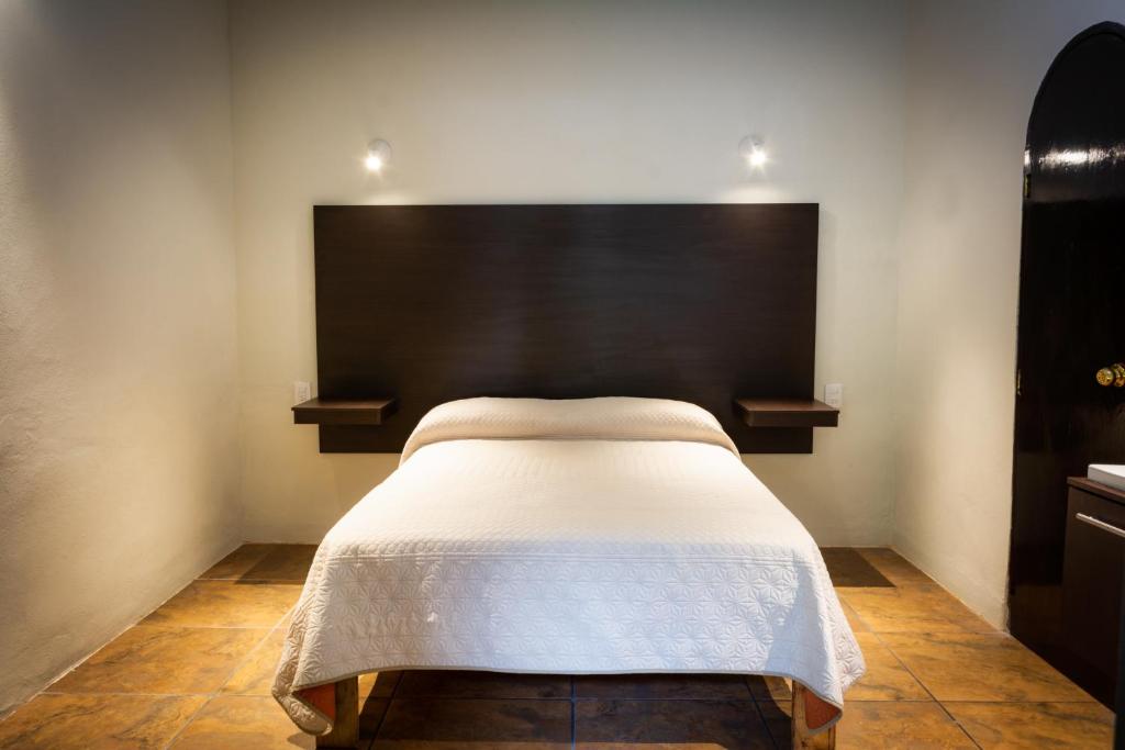 a bedroom with a bed with a black headboard at Hotel Allende Morelia in Morelia