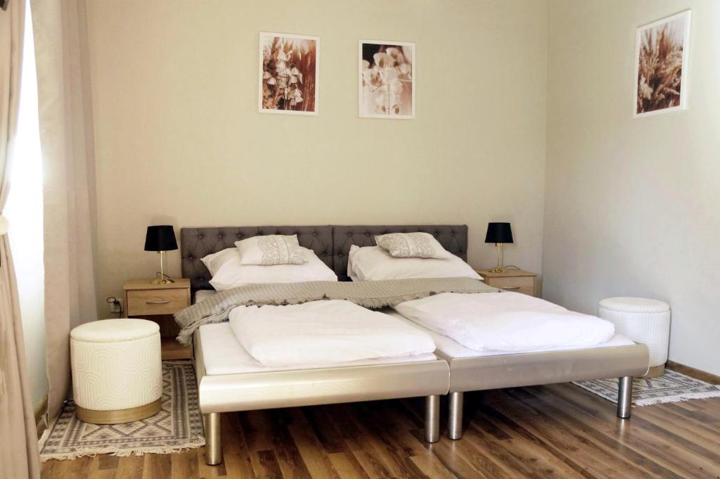 two beds in a room with two tables and two lamps at Apartament Zacisze in Wieliczka