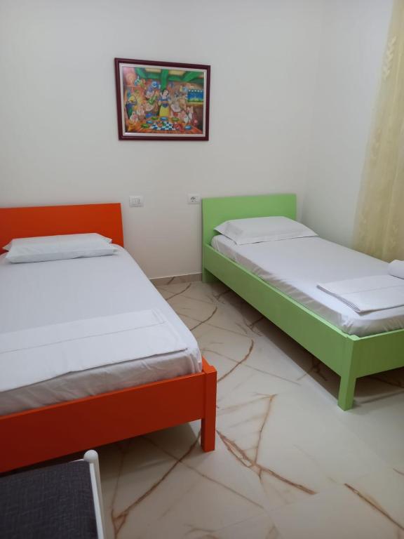 una camera con due letti e una foto a parete di Vlora 3D Guesthouse a Vlorë