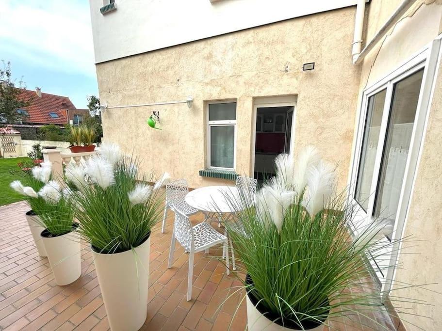 a patio with potted plants and a table and chairs at La Villa Marine*Familiale et Conviviale in Coudekerque-Branche