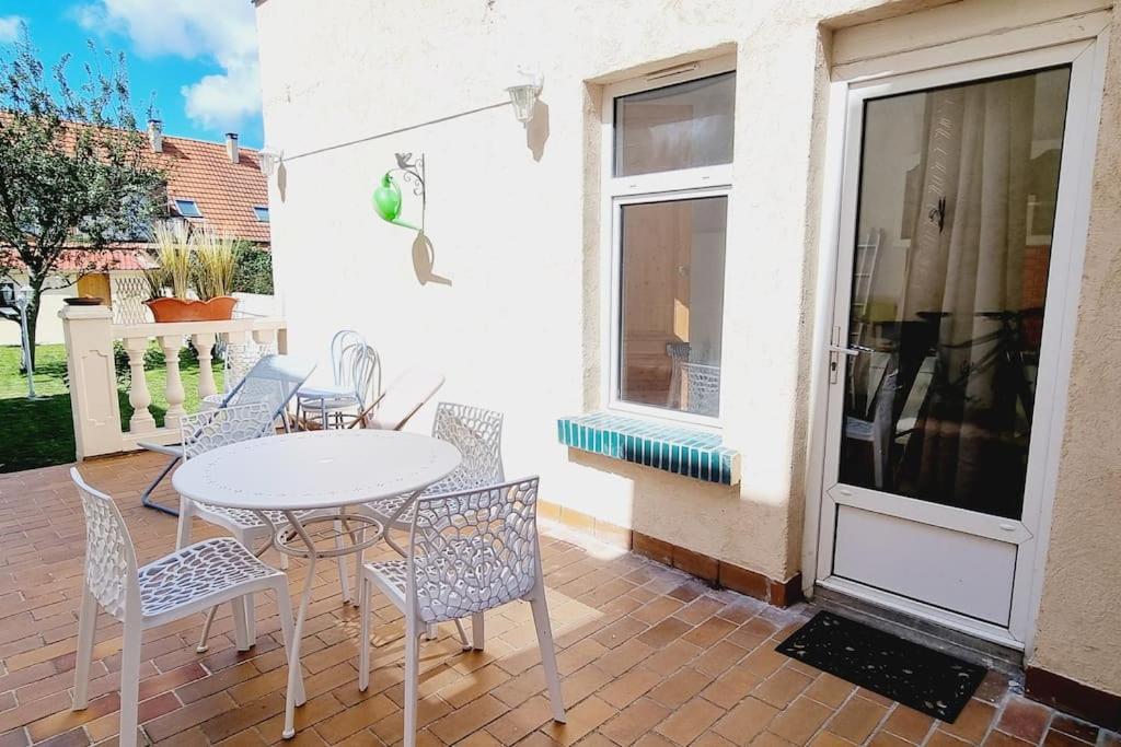 a patio with a table and chairs and a window at La Villa Marine*Familiale et Conviviale in Coudekerque-Branche