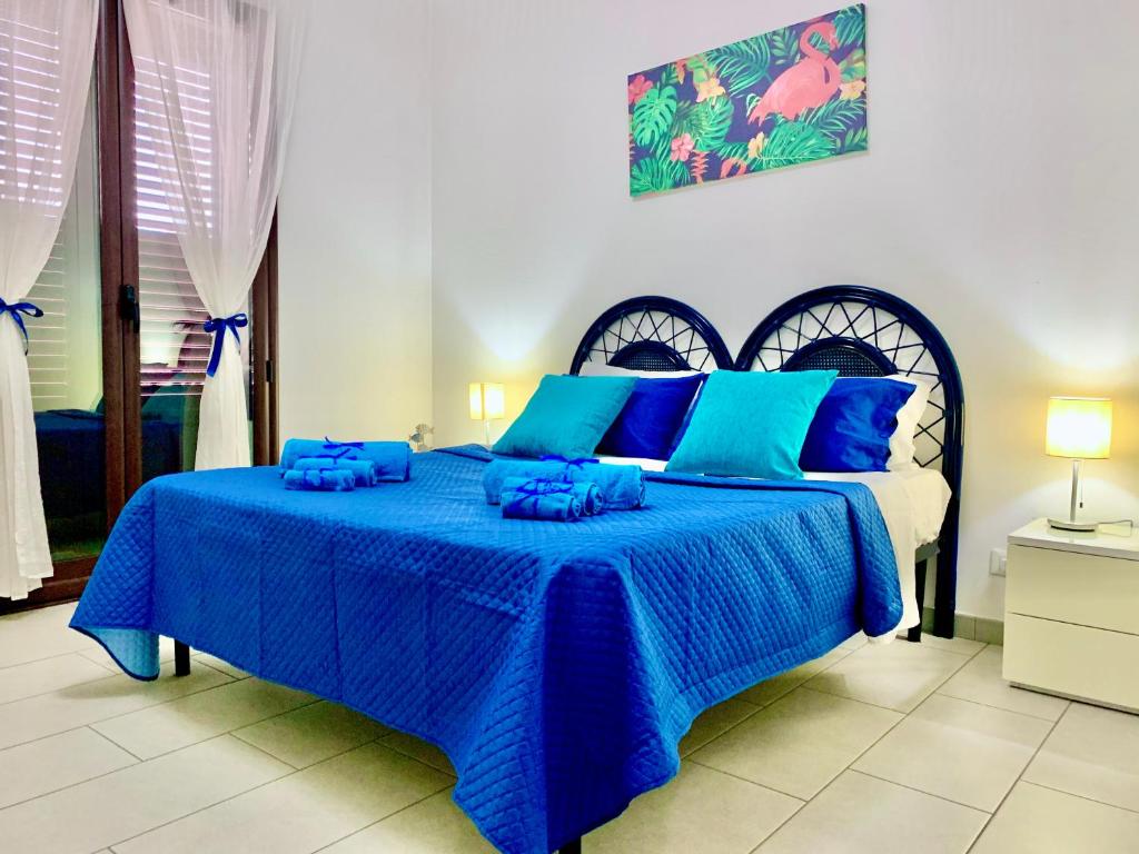 a blue bed with blue pillows in a bedroom at DGS APARTHOTEL in Trapani