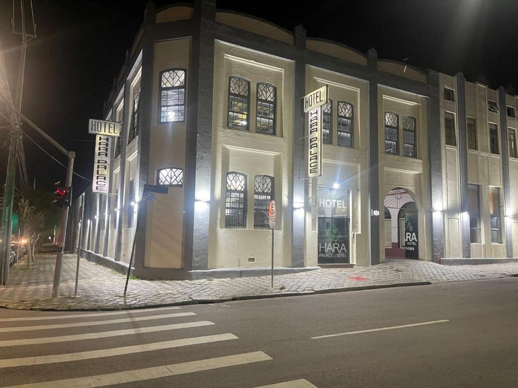 um edifício na esquina de uma rua à noite em Hara Palace Hotel em Curitiba