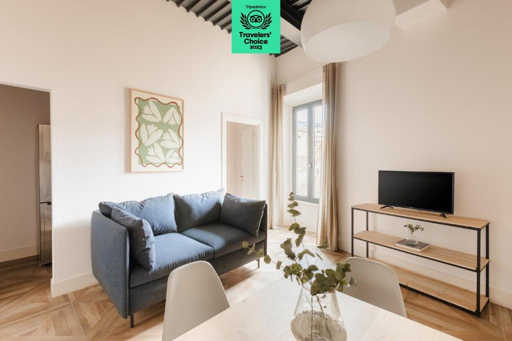 un soggiorno con divano blu e TV di Sonder Barberini a Roma