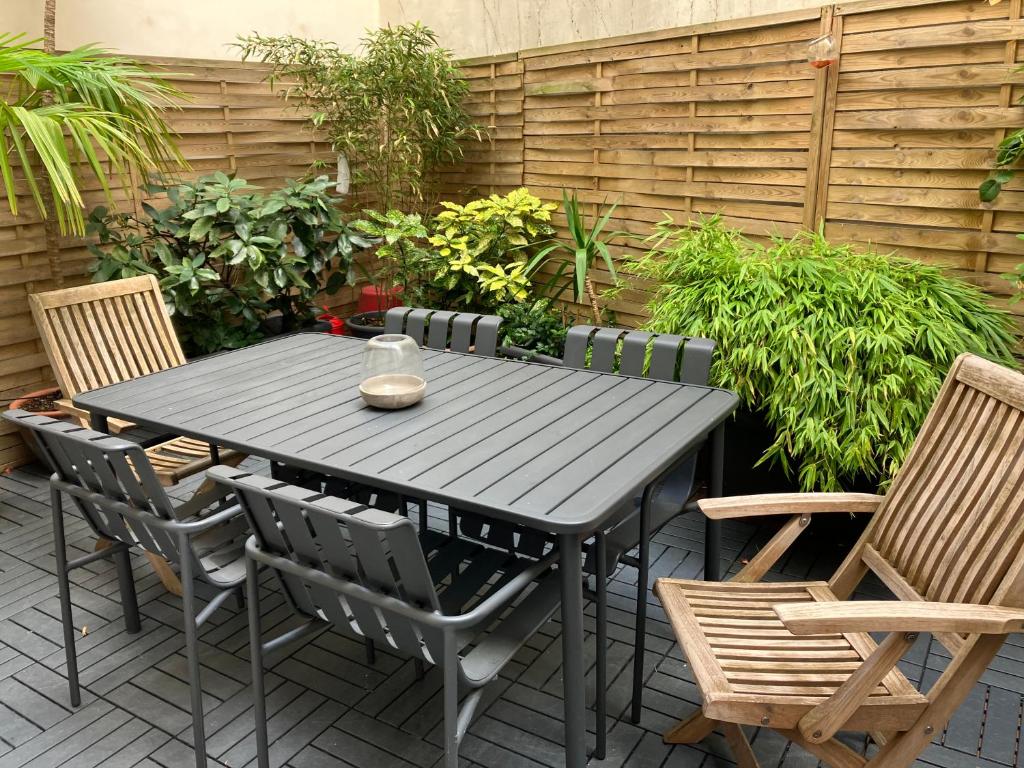 - une table et des chaises noires sur la terrasse dans l'établissement Rare à Paris, magnifique souplex familial, 3 chambres doubles, grande terrasse, très frais en été, à Paris