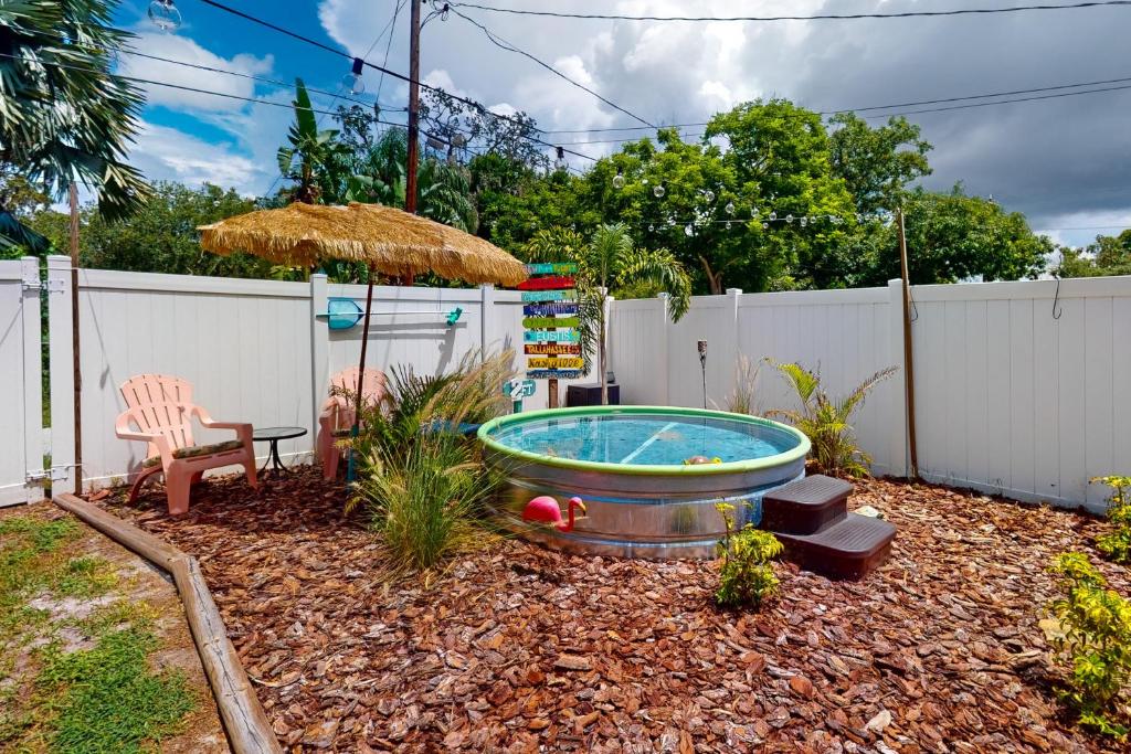 a hot tub in a yard with a fence at Bunglow Boogie Bunkhouse in New Port Richey